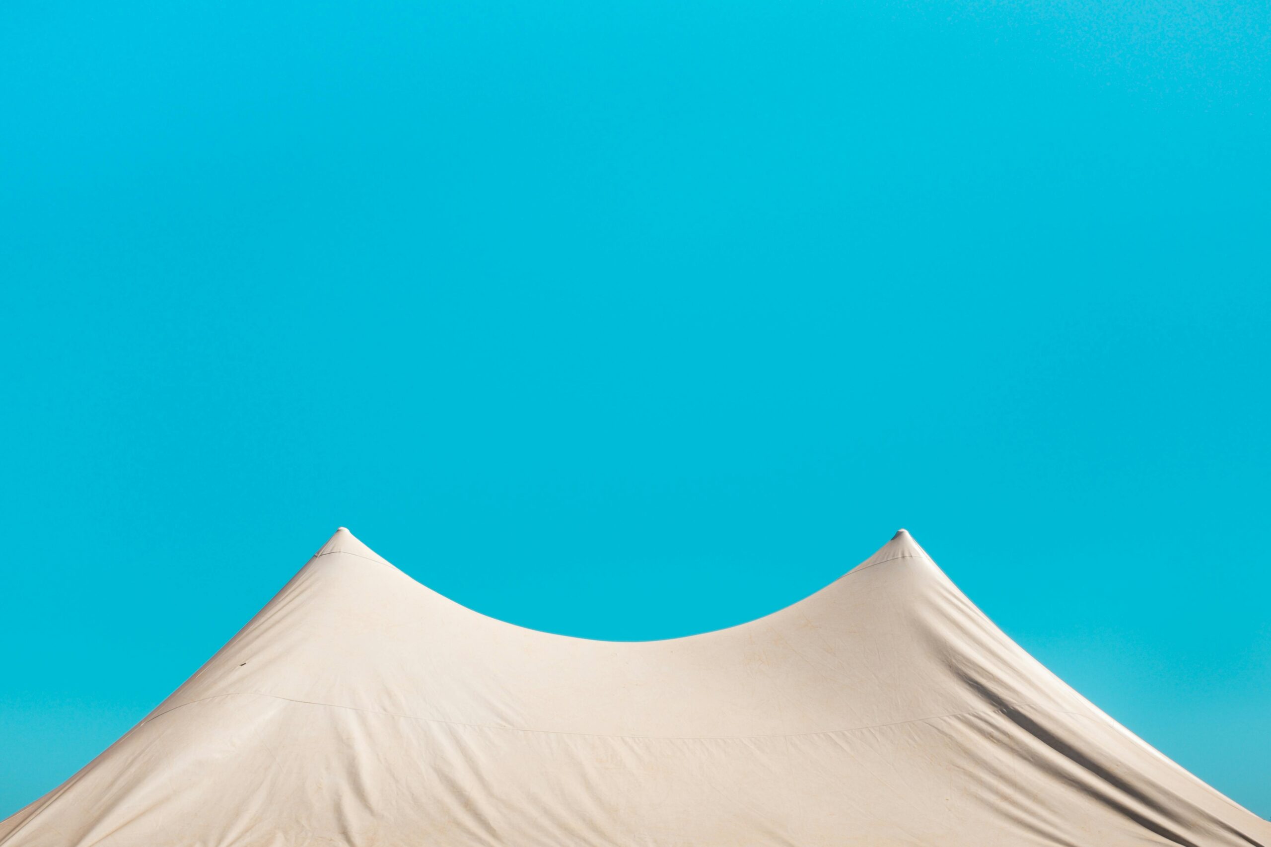 Minimalist tent roof against a vivid blue sky in Brazil, creating a serene summer scene.